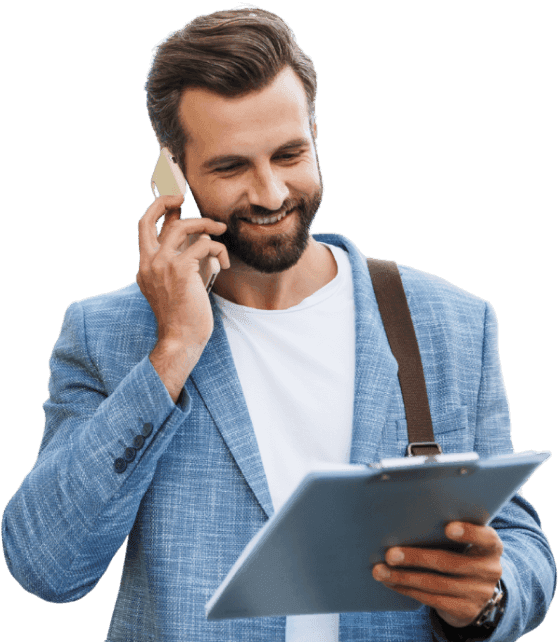 A business owner on a phone call, holding a clipboard, highlighting the busy schedule of managing a business's and hassles of compliances.